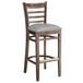 A Lancaster Table & Seating wooden bar stool with a light gray vinyl seat.