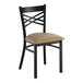 A black metal chair with a cross back design and a taupe vinyl padded seat.