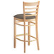 A Lancaster Table & Seating wooden ladder back bar stool with a taupe cushion.