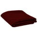 A folded burgundy table cover.