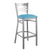 A Lancaster Table & Seating metal bar stool with a blue vinyl padded seat.