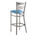A Lancaster Table & Seating clear coated metal cross back bar stool with a blue vinyl padded seat.