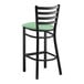 A Lancaster Table & Seating black ladder back bar stool with a seafoam green vinyl padded seat.