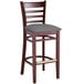 A Lancaster Table & Seating mahogany wood bar stool with a dark gray vinyl seat.