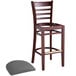 A Lancaster Table & Seating mahogany wood bar stool with a detached dark gray vinyl seat.