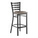 A black metal bar stool with a ladder back design and a dark gray vinyl padded seat.