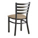 A black Lancaster Table & Seating ladder back chair with a taupe vinyl cushion.