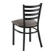A black ladder back chair with a dark gray vinyl padded seat.