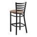 A Lancaster Table & Seating black metal ladder back bar stool with a taupe vinyl padded seat.