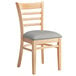 A Lancaster Table & Seating wooden chair with a light gray cushion.