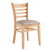 A Lancaster Table & Seating wooden chair with a light gray vinyl seat.