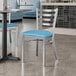 Two Lancaster Table & Seating blue vinyl padded chairs on a table in a restaurant.