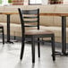 A Lancaster Table & Seating wood ladder back chair with a taupe vinyl seat detached from the chair.
