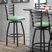 A Lancaster Table & Seating black ladder back swivel bar stool with a seafoam vinyl padded seat.