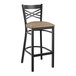 A Lancaster Table & Seating black cross back bar stool with a taupe cushion.