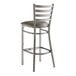 A Lancaster Table & Seating metal bar stool with a dark gray cushion on the seat.