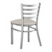 A Lancaster Table & Seating metal ladder back chair with a light gray cushion.