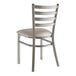 A Lancaster Table & Seating metal ladder back chair with a light gray vinyl padded seat.
