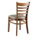A Lancaster Table & Seating wooden ladder back chair with a dark gray vinyl seat.