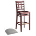 A Lancaster Table & Seating mahogany wood bar stool with light gray vinyl seat.