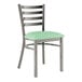 A Lancaster Table & Seating metal ladder back chair with a detached green vinyl padded seat.