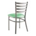 A Lancaster Table & Seating metal restaurant chair with a seafoam green vinyl padded seat and ladder back.