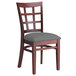 A Lancaster Table & Seating mahogany wood chair with dark gray vinyl seat and window back.