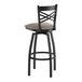 A black metal swivel bar stool with a cross back design and a dark gray vinyl padded seat.