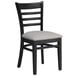 A black Lancaster Table & Seating wood chair with a light gray vinyl seat.