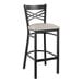 A black Lancaster Table & Seating cross back bar stool with a light gray cushion.