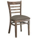 A Lancaster Table & Seating wooden restaurant chair with a taupe cushion.