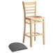 A Lancaster Table & Seating wood bar stool with a dark gray vinyl seat.