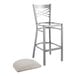 A Lancaster Table & Seating metal bar stool with a light gray cushion on the seat.