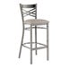 A Lancaster Table & Seating metal cross back bar stool with a light gray cushion