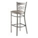 A Lancaster Table & Seating clear coat finish cross back bar stool with a light gray cushion on the seat.