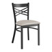 A black Lancaster Table & Seating metal chair with a light gray padded seat.