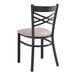 A black Lancaster Table & Seating metal chair with a light gray cushion.