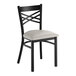 A black cross back chair with a light gray vinyl padded seat.