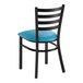 A black ladder back chair with a blue vinyl padded seat.