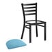 A black Lancaster Table & Seating ladder back chair with a blue vinyl padded seat.