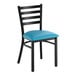 A black ladder back chair with a blue vinyl padded seat.