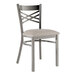 A Lancaster Table & Seating metal cross back chair with a light gray cushioned seat.