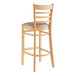 A Lancaster Table & Seating wood ladder back bar stool with a light gray vinyl seat.