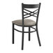 A black Lancaster Table & Seating metal chair with a dark gray cushion.