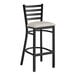 A black Lancaster Table & Seating ladder back bar stool with a light gray cushion.