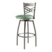 A Lancaster Table & Seating clear coat finish metal cross back swivel bar stool with a seafoam vinyl padded seat.
