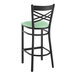 A Lancaster Table & Seating black cross back bar stool with a seafoam green padded seat.