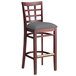 A Lancaster Table & Seating mahogany wood bar stool with a dark gray cushion seat.