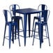 A Lancaster Table & Seating blue metal bar height table with four blue chairs.