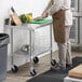 A man cutting vegetables on a Regency stainless steel work table.